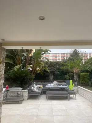 a patio with couches and a table and chairs at Studio proche mer avec piscine Cros de cagnes in Cagnes-sur-Mer
