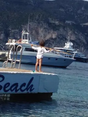 a young child standing on a dock near a boat at St JEAN CAP FERRAT CENTRAL CONTEMPORARY LOVELY WIFI in Saint-Jean-Cap-Ferrat