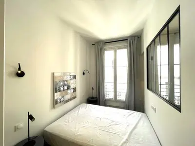 a white bedroom with a bed and a window at Hypercentre lamartine 404 in Nice