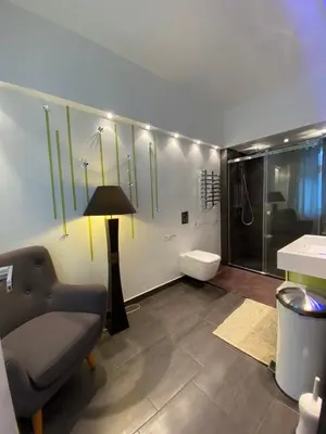 a bathroom with a chair and a glass shower at Villa avec piscine, Nice Centre in Nice