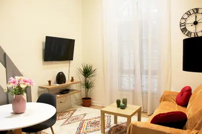 a living room with a couch and a table at Lofty - Massena sq - 5 min walk Beach in Nice