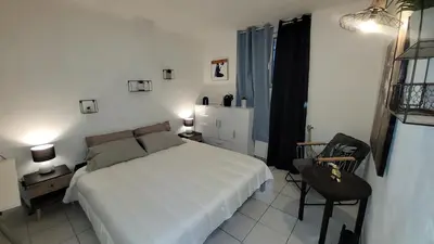 a bedroom with a white bed and a chair at BEACH APPART in Nice