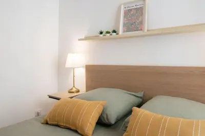 a bedroom with a bed with a headboard and two pillows at #44 1 BDR Flat Cap AC balcony 5mins walk to beach in Nice