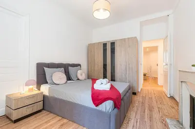 a bedroom with a large bed and a fireplace at FEEL HOME - FOCH 28 in Nice