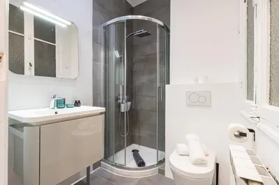 a bathroom with a shower and a toilet and a sink at FEEL HOME - FOCH 28 in Nice