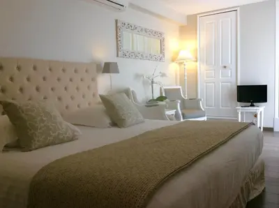 a bedroom with a large bed and two chairs at Villa Kilauea B&B in Nice