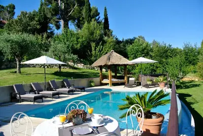 a pool with tables and chairs and umbrellas at Villa Kilauea B&B in Nice