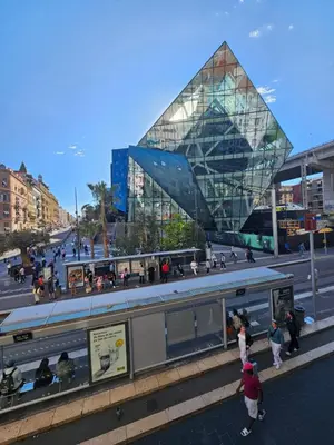 a large glass building with people standing near a bus at Boutique Studio 2 in Nice