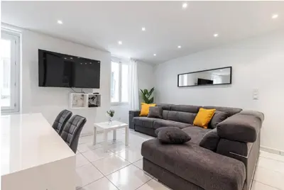 a living room with a couch and a tv at Grand appartement- Le Port A/C in Nice