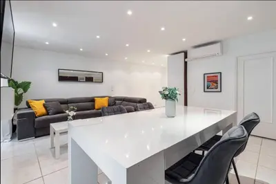 a kitchen and living room with a white table and chairs at Grand appartement- Le Port A/C in Nice