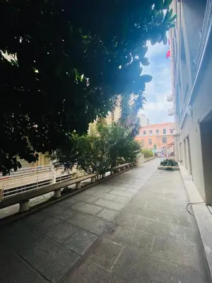 an empty street with benches and a building at Promenade des Anglais /Carré d'or - 2 mins plages in Nice