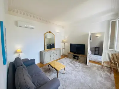 a living room with a blue couch and a television at Promenade des Anglais /Carré d'or - 2 mins plages in Nice