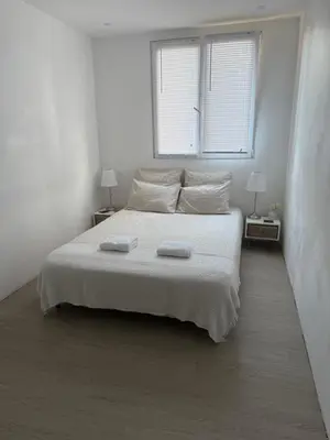 a white bedroom with a bed with two towels on it at Location dans résidence privée,sécurisée ,parking gratuit , 1 minute du tramway, à 9 minute du centre ville, accessible à plusieurs transports in Nice