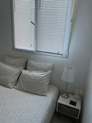 a bedroom with a bed with a window and a lamp at Location dans résidence privée,sécurisée ,parking gratuit , 1 minute du tramway, à 9 minute du centre ville, accessible à plusieurs transports in Nice