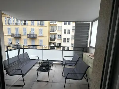 a balcony with chairs and a table on a balcony at Superbe Appartement terrasse 2P à 5 min à pied du vieux Nice, du port et du Tram in Nice