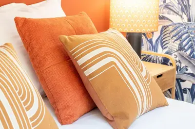 a bed with orange and white pillows on it at #48 Suite Jean top floor terrace 5min walk sea AC in Nice
