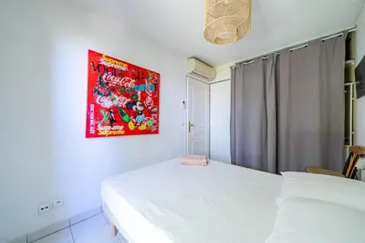 a bedroom with two beds and a painting on the wall at Rez de jardin à 500 m de la plage in Cagnes-sur-Mer