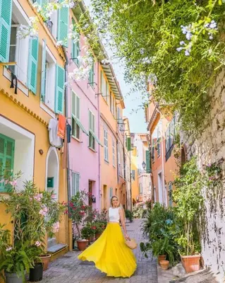 a woman in a yellow dress walking down a street at Signature Penthouse at Villefranche, Steps to Beach, Limited-Time Offer in Villefranche-sur-Mer