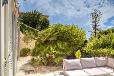 a white couch on a patio with trees and bushes at Mont Boron Exclusive Apartment in Villa Belle Époque in Nice