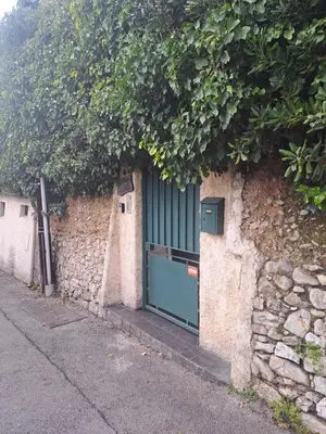 a stone wall with a green door on a building at Maison du bonheur calme et verdure in Nice