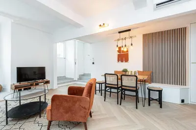 a living room with a table and chairs and a television at Ultra Central 2 Bdr AC & Parking in Nice