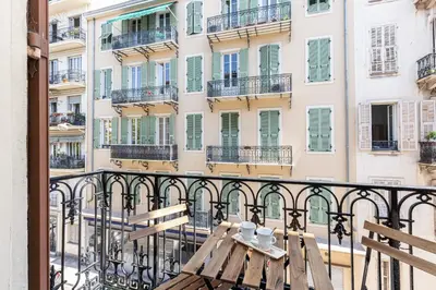a table on a balcony in front of a building at Confort Downtown 2 Bdr in Nice