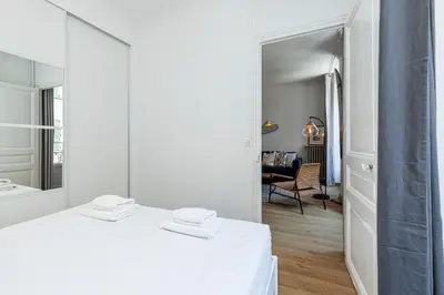 a white room with a mirror and a bed at Confort Downtown 2 Bdr in Nice
