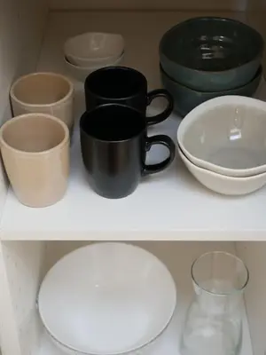 a white shelf with bowls and cups and a black mug at LOVELY STUDIO - Port de Nice in Nice