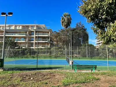 a tennis court in front of a building at Appartement Nice aéroport seafront with pool in Cros-de-Cagnes