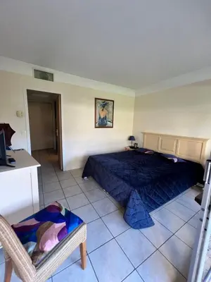 a bedroom with a bed and a chair in it at Appartement Nice aéroport seafront with pool in Cros-de-Cagnes