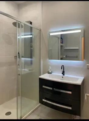 a bathroom with a sink and a shower with a mirror at Luxury apartment In the heart of old town Nice. in Nice
