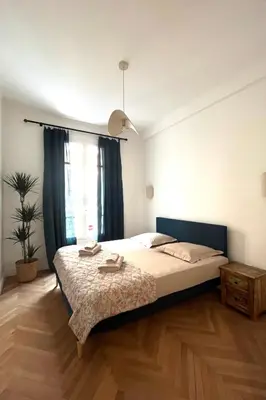 a bedroom with a large bed and a window at CHEZ TAMARA in Nice