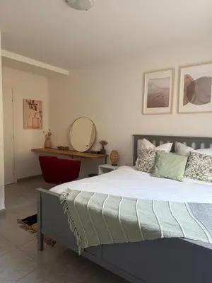 a bedroom with a large bed and a mirror at Bas de Villa à 15 min de Nice avec piscine in Carros