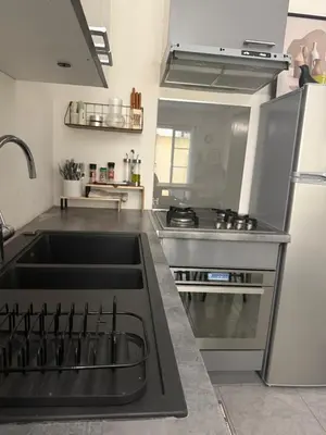 a kitchen with a sink and a stove and a refrigerator at Bas de Villa à 15 min de Nice avec piscine in Carros
