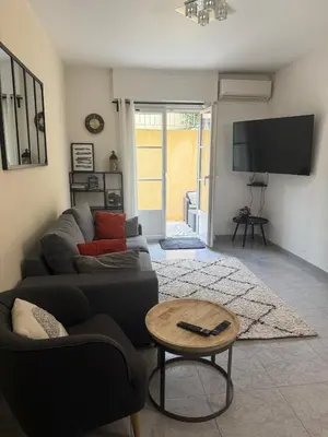 a living room with a couch and a table at Bas de Villa à 15 min de Nice avec piscine in Carros