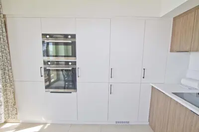 a white kitchen with white cabinets and an oven at Sea Front Palace Promenade in Nice
