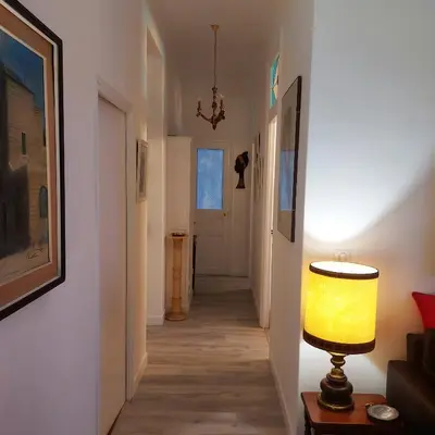 a hallway with a lamp on a table and a door at MAO in Nice