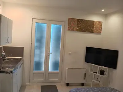 a kitchen with a sliding glass door and a tv at Studio de 14m2 dans une maison in Cagnes-sur-Mer