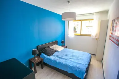 a blue bedroom with a bed and a blue wall at Appartement 3 pièces SoNice au centre de Nice in Nice