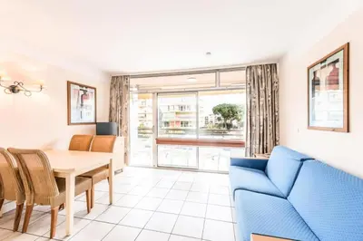 a living room with a table and a blue couch at Résidence Héliotel Marine - maeva Home - Studio 4 Personnes Confort MAE-1778 in Cros-de-Cagnes