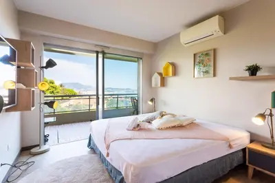 a bedroom with a bed and a large window at BELLES TERRES AP4378 By Riviera Holiday Homes in Nice