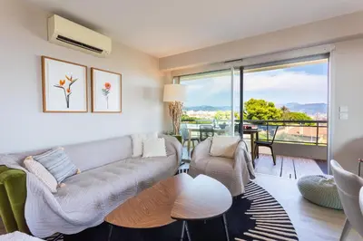 a living room with a couch and a balcony at BELLES TERRES AP4378 By Riviera Holiday Homes in Nice