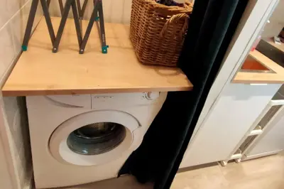 a washing machine with a wooden counter on top of it at «l’Orient Express» joli 2 pièces fonctionnel in Nice