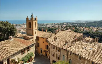 a view of a city with roofs and a clock tower at Awesome Apartment In Cagnes-Sur-Mer in Cagnes-sur-Mer