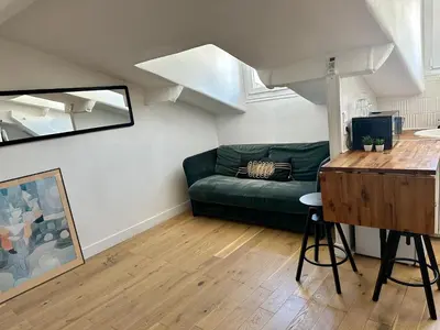 a living room with a green couch and a table at Beau studio au cœur de Nice in Nice