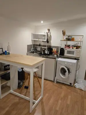 a kitchen with a table and a washing machine at Cabane pas loin de la plage in Cagnes-sur-Mer