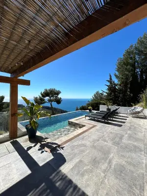 a patio with a pool and a view of the ocean at Èze - Appartement dans bas de villa avec piscine près de Monaco in Èze