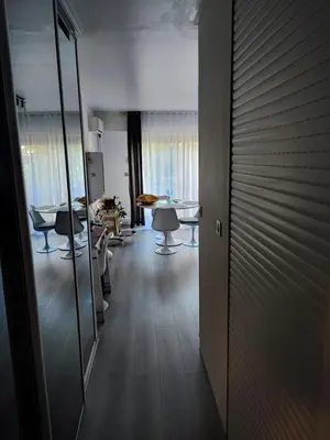 a living room with a table and chairs and a mirror at Studio 31 m² in Nice