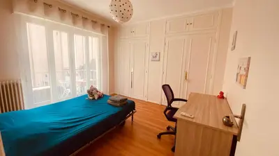 a bedroom with a bed and a desk and a window at Confortable et Spacieux 3pièces, très bien situé in Nice