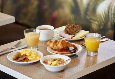 a table topped with plates of breakfast foods and drinks at B&B HOTEL Nice Stade Riviera in Nice